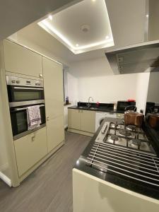 een keuken met een fornuis en een fornuis top oven bij A spacious & modern 3-bed home in Blackburn