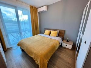 a bedroom with a bed and a large window at Yellow Apart @ Vitosha, Sofia in Sofia