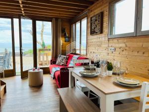 a living room with a red couch and a table at Chalet Bord de Mer CLS Deauville in Cricquebœuf