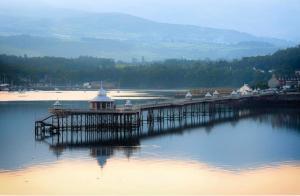 a pier on a body of water with houses at Spacious & Modern 4 Bedroom Holiday Home Gwynedd in Bangor