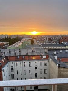 a view of the sunset from the roof of a building at Apartament z pięknym widokiem na zachodni Szczecin in Szczecin