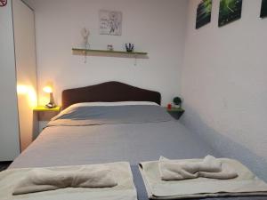 a bedroom with a bed with two towels on it at VINI studio with private parking in Skopje