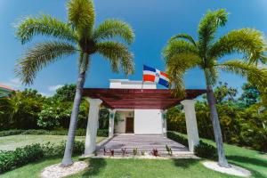 un edificio con dos palmeras delante en Private Villa LaPerla Iberosta 3BDR, Pool, Beach, WiFi, en Punta Cana