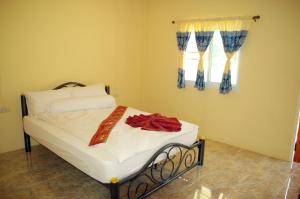 a bedroom with a bed with a red ribbon on it at Tungngoen Resort in Ban Som Poi