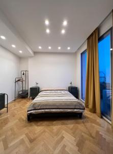 een slaapkamer met een groot bed en een groot raam bij Ermes Apartment - Historic Centre Catania in Catania