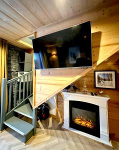 sala de estar con chimenea y TV en Duplex rénové - 2 chambres 7 personnes vue pistes en Les Orres