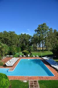 a large swimming pool with lounge chairs around it at Casa del Sol Hotel & Restaurante in Colonia del Sacramento