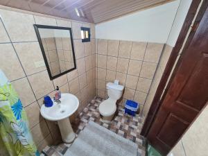 a bathroom with a toilet and a sink and a mirror at Casa Tucan in Drake