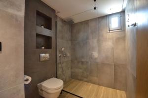 a bathroom with a toilet and a shower at Hotel Evilion Sea And Sun in Nei Poroi