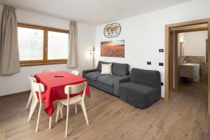 a living room with a table and a couch at Pianeta Oro Chalet Allegra in Livigno