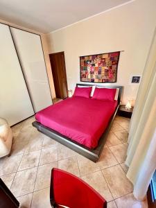 ein Schlafzimmer mit einem roten Bett und einem roten Stuhl in der Unterkunft Catania Duomo Shine in Catania