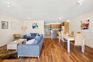 a living room with a blue couch and a table at Apartment 23 Pacific Apartments in Lorne