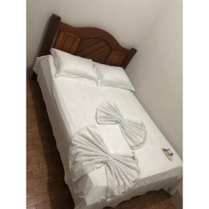 un letto con una coperta bianca con un fiocco sopra di Hotel Cuiabá a Cuiabá