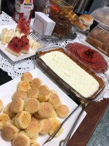 a buffet of food with bread and dip and pies at Hotel Cuiabá in Cuiabá