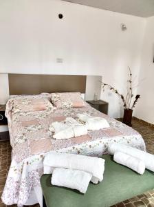 a bedroom with a large bed with towels on it at Posada Los Molles in Colón