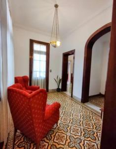 Sala de estar con 2 sillas rojas y espejo en Casa De Vacaciones Estilo Marplantense Temporada 2023 en Mar del Plata
