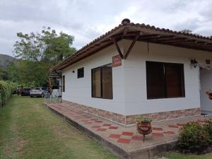 Una casa blanca con un cartel en el costado. en Casa libella, en Carmen de Apicalá