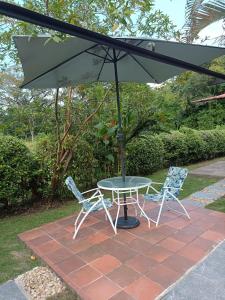 een tafel en twee stoelen onder een paraplu bij Casa libella in Carmen de Apicalá