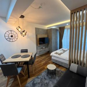 a room with a bed and a table and chairs at President Kop - Silver Ice Apartment in Kopaonik