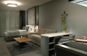 - un salon avec un canapé et une table dans l'établissement THE ROOMS - Hotel & House, à Francfort-sur-le-Main