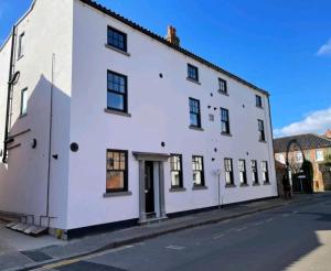 a white building on the side of a street at 2 bed luxury duplex apartment in heart of Holt in Holt