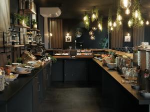 a restaurant with a long counter with food on it at THE ROOMS - Hotel & House in Frankfurt/Main +72 photos
