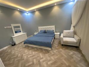 a bedroom with a bed and a chair at شقة بدخول ذاتي in Riyadh