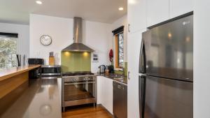 a kitchen with white walls and a stainless steel refrigerator at Mitchell in Dinner Plain