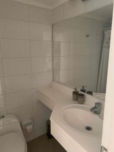 a white bathroom with a sink and a toilet at Precioso departamento en Rocas de Santo domingo in Santo Domingo