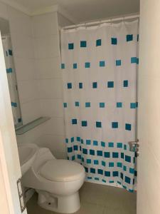 a bathroom with a toilet and a shower curtain at Precioso departamento en Rocas de Santo domingo in Santo Domingo