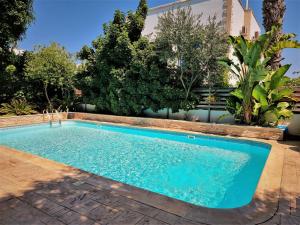 a swimming pool in a yard with trees at Mosaic villa by the sea in Protaras