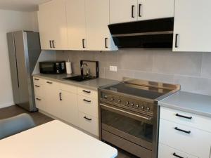 a kitchen with white cabinets and a stove top oven at Stadtquartier 1 EG in Bredstedt