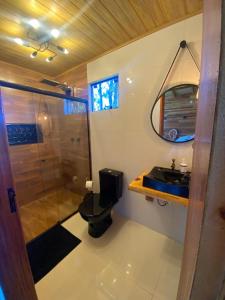 uma casa de banho com um chuveiro, um WC e um lavatório. em Pousada recanto do vinho em Urupema