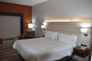 a hotel room with a large bed and a phone at Holiday Inn Express Hotel & Suites McPherson, an IHG Hotel in McPherson