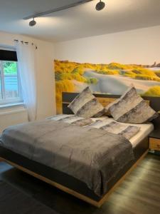 a bedroom with a bed with a painting on the wall at Stadtquartier 1 EG in Bredstedt