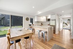 a kitchen with a wooden table and some chairs at Stillwater Chalet B Crackenback in Crackenback