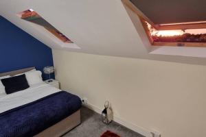 a bedroom with a blue and white bed and a window at Cosy 3BR Hastings House in Maidstone Kent in Kent
