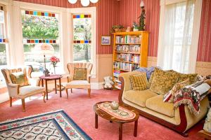 een woonkamer met een bank en stoelen en een boekenplank bij Bridgeford House in Eureka Springs