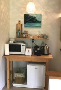 a kitchen counter with a microwave and appliances on it at Lakehouse Studio in Kerikeri