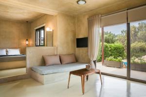 a bedroom with a couch and a bed and a window at Sotiris villas in Svoronata