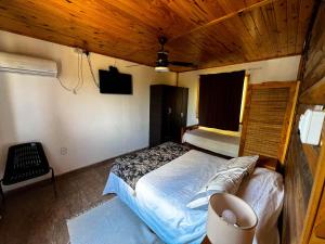 sypialnia z łóżkiem i drewnianym sufitem w obiekcie el PARAISO w mieście Anisacate