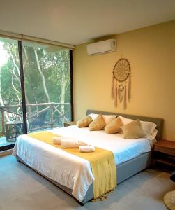 a bedroom with a large bed and a window at Naajal Tulum Boutique Hotel - Magic & Jungle in Tulum