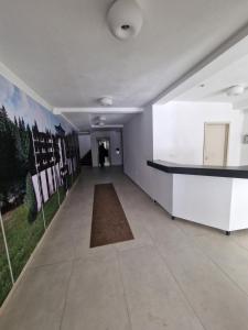 um quarto vazio com um corredor com uma parede com cartazes em Xenia Apartment em Kopaonik