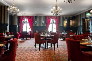 uma sala de jantar com mesas, cadeiras e lustres em Best Western Hotel Gamla Teatern em Östersund