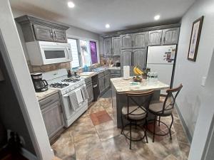 uma cozinha com armários de madeira e uma ilha de cozinha com bancos de bar em Cozy Updated 3-BR apartment near Peace Bridge em Buffalo