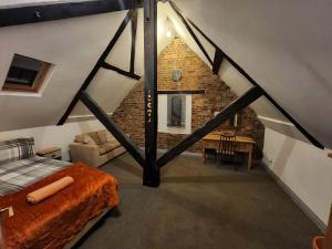 a attic room with a bed and a brick wall at The Olde Chapel 2 Bedroom Flat in Market Deeping
