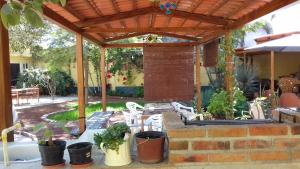 eine Terrasse mit einer Holzpergola und Topfpflanzen in der Unterkunft Casa Vida Bella in Chapala