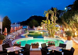 a resort with a pool and tables and chairs at Casa Di Meglio Dependance in Ischia