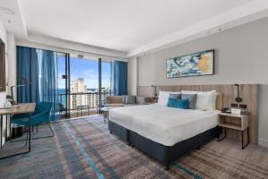 une chambre d'hôtel avec un lit et un canapé dans l'établissement Crowne Plaza Surfers Paradise, an IHG Hotel, à Gold Coast