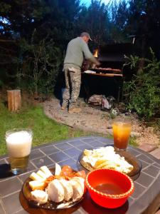 a man playing on a piano with food on a table at Cabaña Los Cipreses in San Carlos de Bariloche